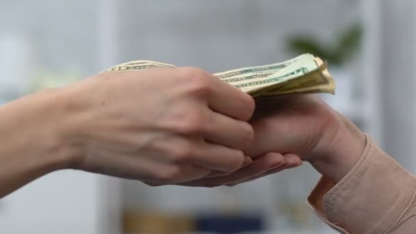 Женщина дает доллар наличными пожилой женщине, волонтер помогает пенсионеру, поддержка — стоковое видео