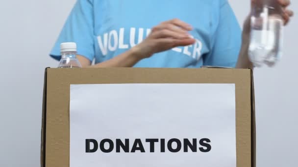 Volunteer packing food in cardboard box, gathering donations for nursing home — Stock Video