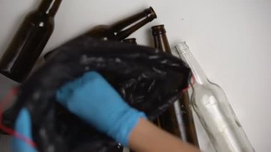 Plastik torbada cam şişeleri toplayan atık ayıklama tesisi işçisi, hammadde