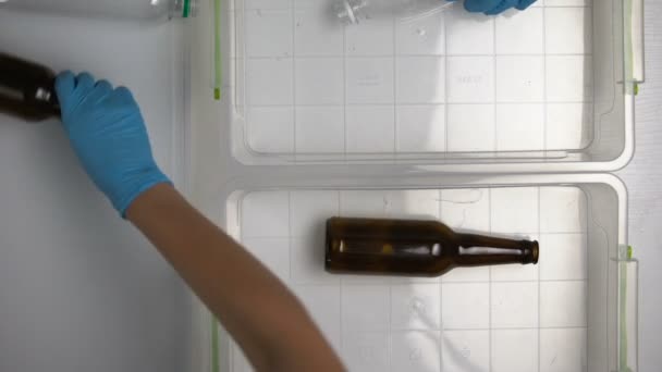 Mãos voluntárias classificando garrafas de vidro e plástico on-line na instalação de reciclagem — Vídeo de Stock