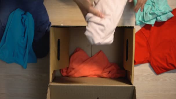 Упаковка использованной одежды в картонной коробке, пожертвование бедных людей, церковь — стоковое видео