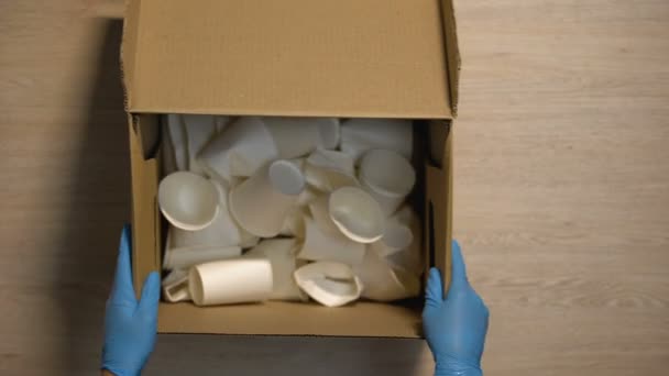 Werknemer in beschermende handschoenen doos met papieren cups veilige cellulose met behulp van — Stockvideo