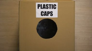 Karton kutuya plastik kapaklar atan bayan yeniden kullanılabilir malzeme toplama kullanımı