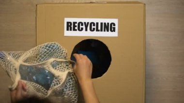 Geri dönüştürülebilir malzemeler için kutuya plastik atık atan insanlar, çöp kullanarak