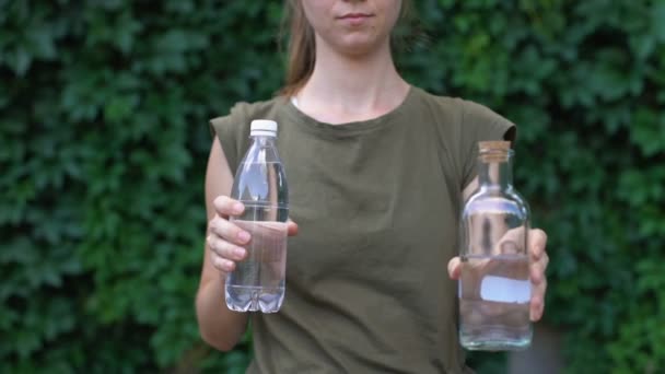 Responsible lady choosing reusable glass bottle instead of plastic, save planet — Stock Video