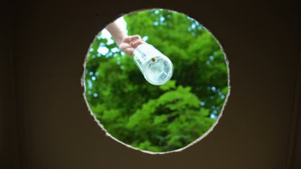 Hand legt Glasflasche in Container für wiederverwendbare Materialien, wiederverwendbare Abfälle — Stockvideo