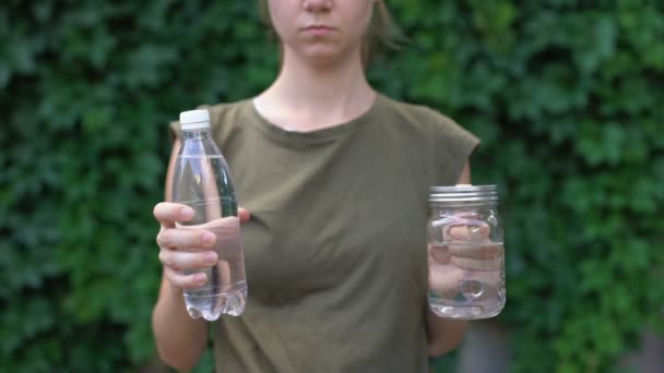 Senhora mostrando caneca de vidro para câmera, preferindo-o a garrafa de plástico, economizando terra — Vídeo de Stock