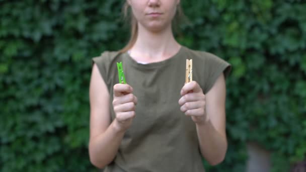 Vrouw demonstreren houten wasknijper prefererenhet aan plastic onschadelijk materiaal — Stockvideo