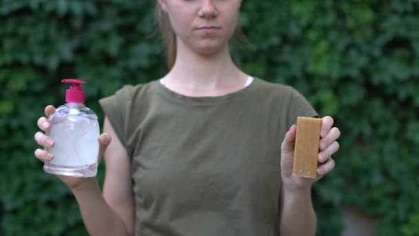 Женщина предпочитает мыло для стирки химическому моющему средству, выбирая безвредный материал — стоковое видео