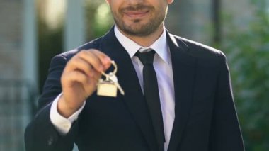 Gülümseyen emlakçı ev anahtarı gösteren, özel mülkiyet satın alma mülkiyet
