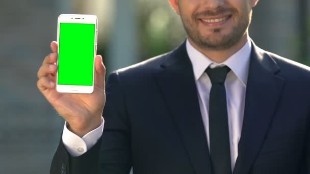 Feliz empresario sosteniendo la pantalla verde del teléfono inteligente, aplicación en línea, tecnología moderna — Vídeo de stock