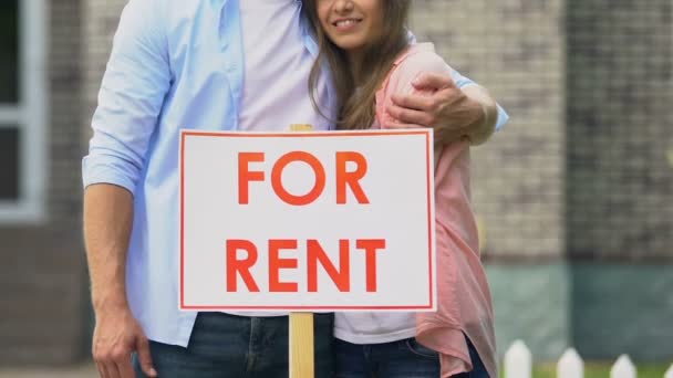 Souriant jeune couple debout derrière à louer signe extérieur chalet, immobilier — Video