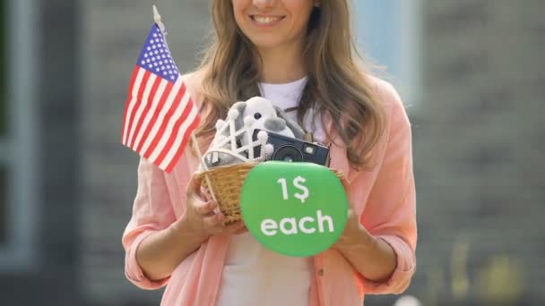 Mosolygó nő gazdaság cucc kosár, 1 dollár minden jel és az amerikai zászló — Stock videók