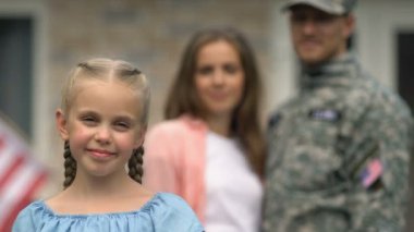 Gülen kız Amerikan bayrağı yama gösteren, arka planda anne sarılma, vatansever