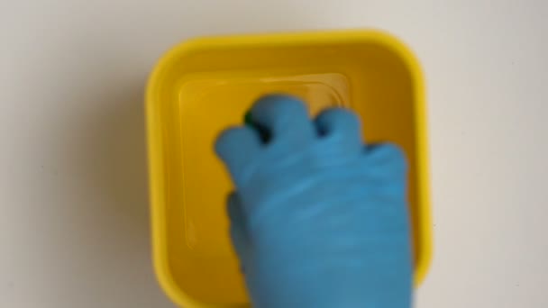 Persoon in handschoenen die plastic doppen in bak-, sorteer-en recycling afval plaatst — Stockvideo