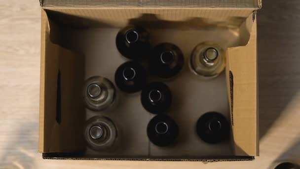 Hände legen Bierflasche in Box mit Glasschild, Mülltrennung und Recycling — Stockvideo