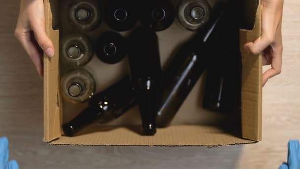 Руки, дающие человеку в перчатках коробки с бутылками и стеклянной вывеской, точка сбора — стоковое видео