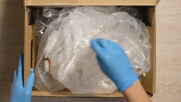 Arbeiter in Handschuhen checken Box mit Plastikmüll, Sortier- und Recyclingkonzept — Stockvideo