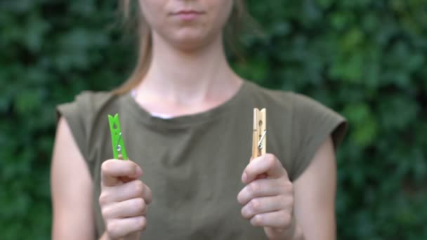 Frau schlägt hölzerne Wäscheklammer statt Plastikklammer vor, umweltfreundliches Produkt — Stockvideo