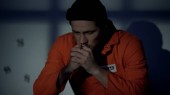Evropský uvězněný muž se stříbrným křížkem a modlením se v cele vinen