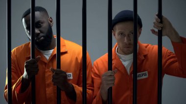 Kafkas ve Afro-Amerikan mahkumlar hapishane çubukları tutan ve kamera arıyor