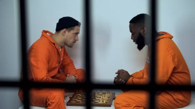 Hücrede satranç oynayan kafkas ve afro-amerikan hapishane mahkûmları, hapishane hobisi