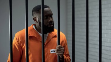 Saldırgan mahkum parmaklıklar tutuyor ve nöbet bekliyor, yetersiz suçlu