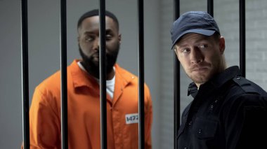 Hapishane gardiyanı ve suçlu geriye bakıyor, düzenleme yapıyor, yolsuzluk ve rüşvet