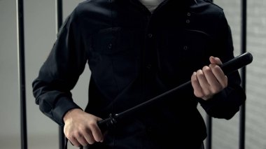 Hapishane güvenlik görevlisi Truncheon ile hücre yakınında ayakta, sıkı rejim, şiddet