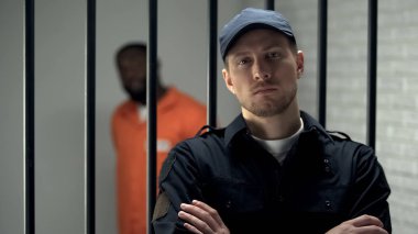 Prison Warden esir Afro-Amerikan ile hücre yakınında kamera ayakta arıyor
