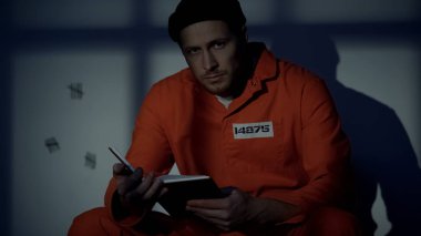 Kafkas mahkumu kitap okuyor ve kameraya bakıyor, hapiste kendi kendine eğitim
