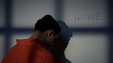 Hapsedilmiş erkek hücre duvarında ev yazma, evde aşk hissi, özgürlük için umut