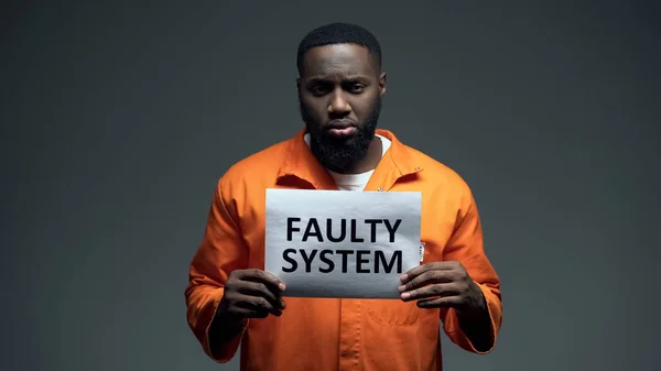 非裔美国男性囚犯持有错误系统标志在细胞 — 图库照片