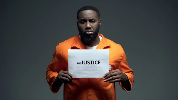 黒い囚人が Unjustice のサインを保持し 人権保護に関する認識 — ストック写真