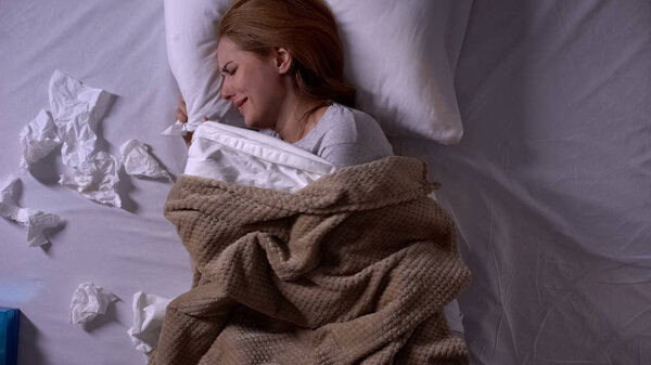 Женщина плачет лежа в постели, держа подушку, много тканей рядом, жизненные трудности
