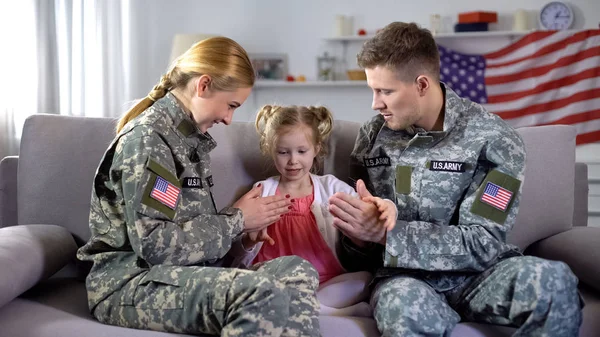 欢快的美国军人夫妇在家里和小女儿玩拍蛋糕 — 图库照片