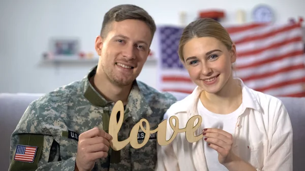 Smiling American Soldier His Girlfriend Showing Wooden Love Sign Camera — Stock Photo, Image