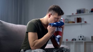 Erkek asker öpüşme katlanmış Abd bayrağı, yoldaş cenaze için hazırlanıyor, melankoli