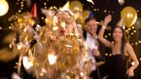 Lachende Jonge Dame Waait Gouden Confetti Camera Dansen Mensen Achtergrond — Stockfoto