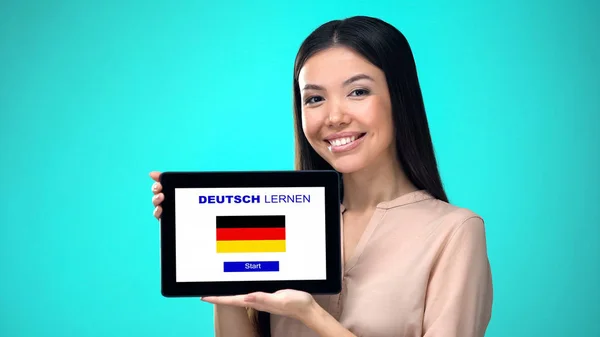 女性持有平板电脑与学习德语应用程序 准备开始课程 — 图库照片