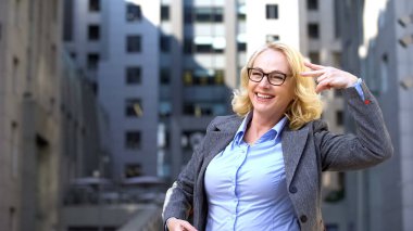 Ofis binası dışında dans overjoyed kadın yönetmen, promosyon kutluyor