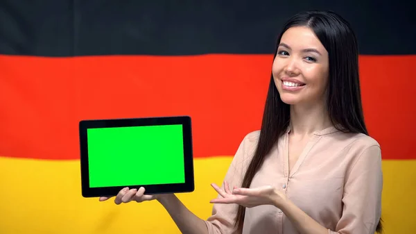女孩拿着带绿屏的平板电脑 背景上的德国国旗 — 图库照片
