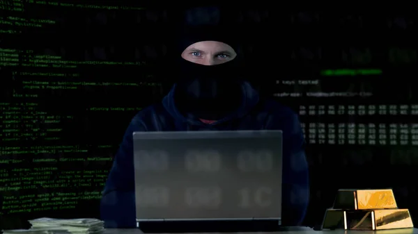 Hacker mit Sturmhaube begeht Cyber-Verbrechen auf Laptop, Zahlencodes Hintergrund — Stockbild Hacker Mit Sturmhaube Begeht Cyber Verbrechen Auf Laptop Zahlencodes Hintergrund — Stockfoto