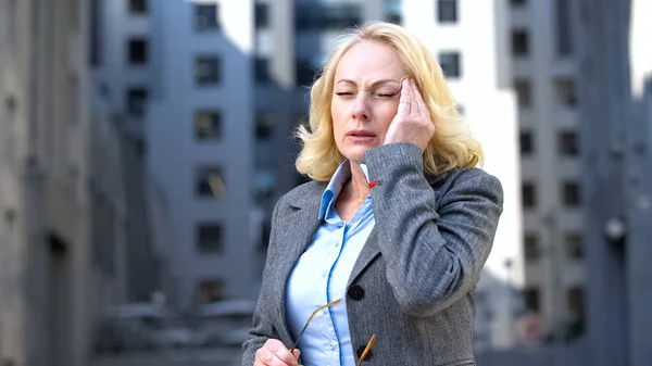 片頭痛 仕事の圧力 忙しいライフスタイルの緊張に苦しむスーツの病気の高齢女性 — ストック写真