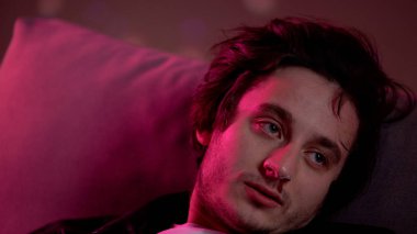 Gece kulübünde koçta oturan kanlı burunlu kokain bağımlısı adam halüsinasyon