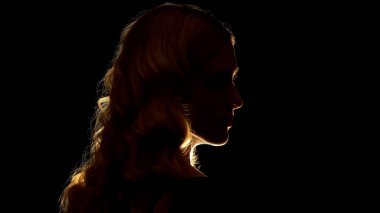 Baştan çıkarıcı sarışın bayan yan arıyor, siyah arka plan, gizem izole