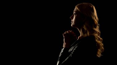 Kadın günahkar dua yukarı bakıyor, siyah arka plan üzerinde izole, itiraf