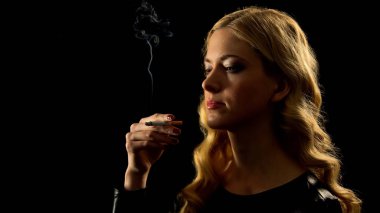 Sigara tutan siyah elbiseli kadın, zararlı ve sağlıksız alışkanlık, bağımlılık