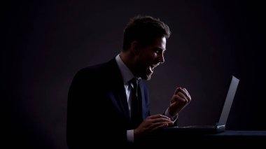 Genç tüccar laptop üzerinde çalışan, başarılı anlaşma yapma, Evet jest gösteren