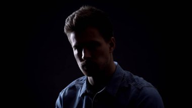 Siyah arka planda izole kamera bakıyor genç adam, kişilik karanlık tarafı